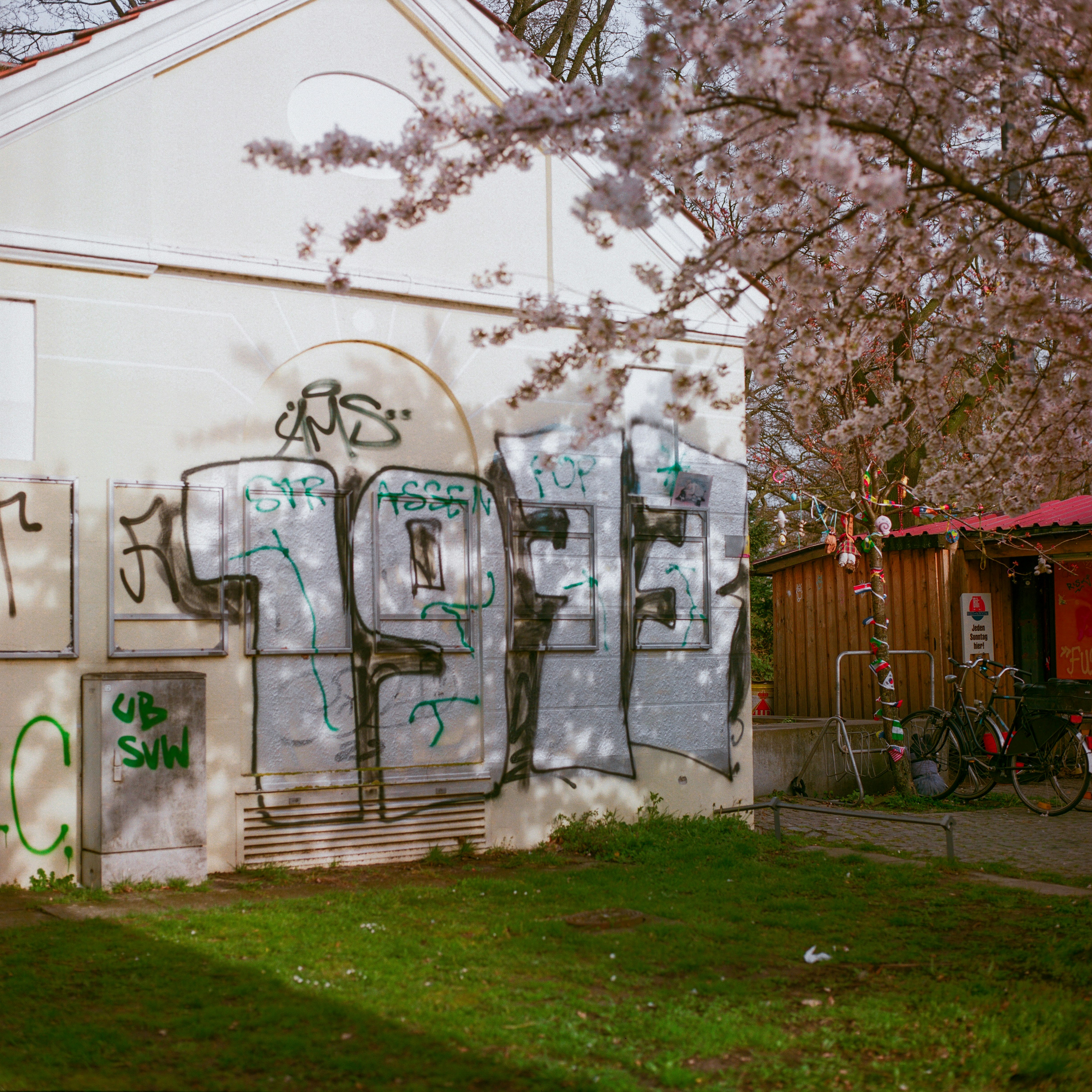 white and green graffiti on white concrete building